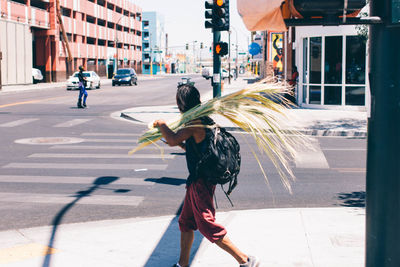 Woman with umbrella on road in city