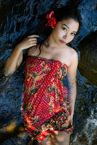 High angle portrait of beautiful young woman lying in river