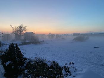 Scenic view of snow covered landscape against sky during sunset