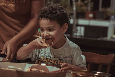Young woman eating food at restaurant