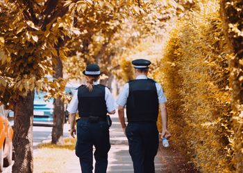 Rear view of two people walking in autumn