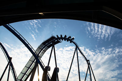 Low angle view of silhouette rollercoaster against sky