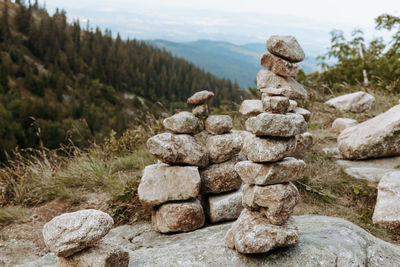 Stack of stones on rock against sky