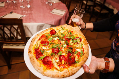 Cropped hand of person holding pizza