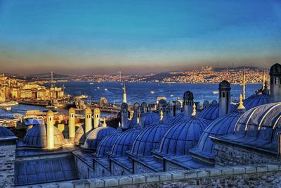 High angle view of mosque and buildings by strait in city 