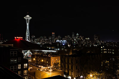 Illuminated cityscape against sky at night