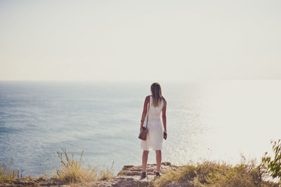 Full length of woman standing by sea against sky