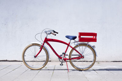 Bicycle parked against red wall