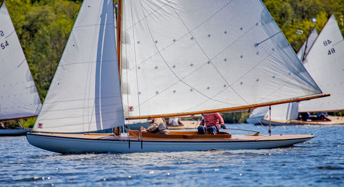 Men on sailboats sailing in sea