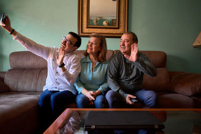 Family talks online with a smartphone in their living room