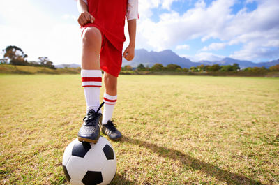 Low section of man playing soccer on field