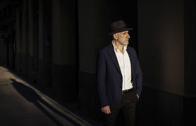 Portrait of adult man in suit with hat on street during sunset. madrid, spain