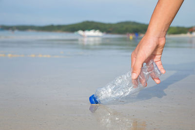 Person holding bottle on beach