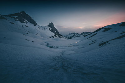 Snow covered mountain against sky during sunset