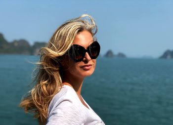 Portrait of woman wearing sunglasses against sea