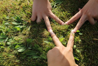 Low section of woman with hand on grass