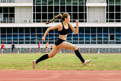 Full length of young woman exercising at park