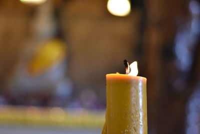 Close-up of burning candles on cutting board