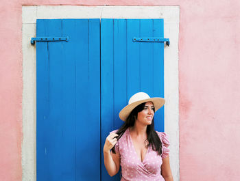 Woman standing by door while looking away