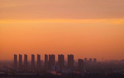 Modern buildings against sky during sunset