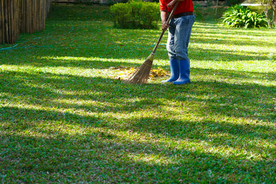 A man worker sweeps leaves in the public park