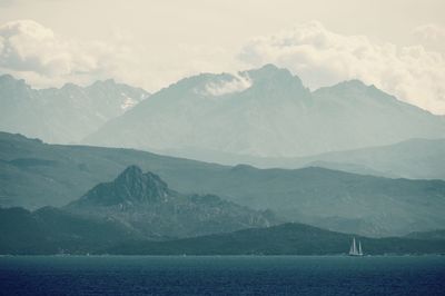 Scenic view of sea and mountains against sky