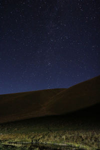 Scenic view of landscape against star field