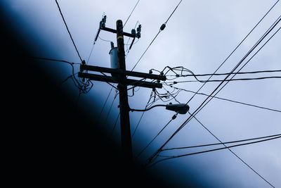 Low angle view of power lines against sky