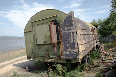 Abandoned truck on field against sky