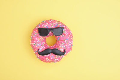 Close-up of pink cake against yellow background