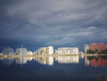 Reflection of buildings in lake against sky