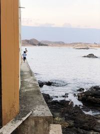 People on beach by sea against sky