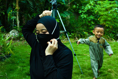 Friends standing on field in forest
