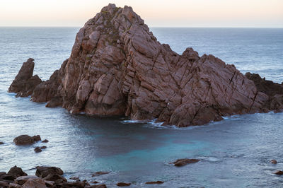 Scenic view of rocks in sea against sky