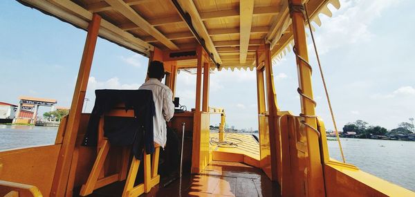 Rear view of man on boat in sea