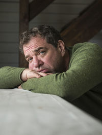 Close-up of sad man leaning on table