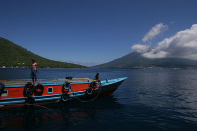 People on boat against blue sky