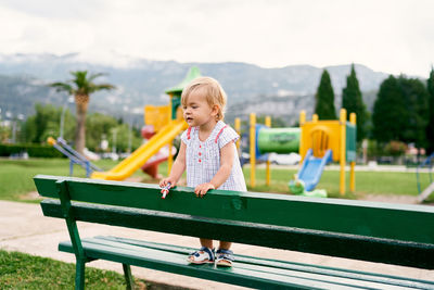 Full length of woman sitting on bench in park