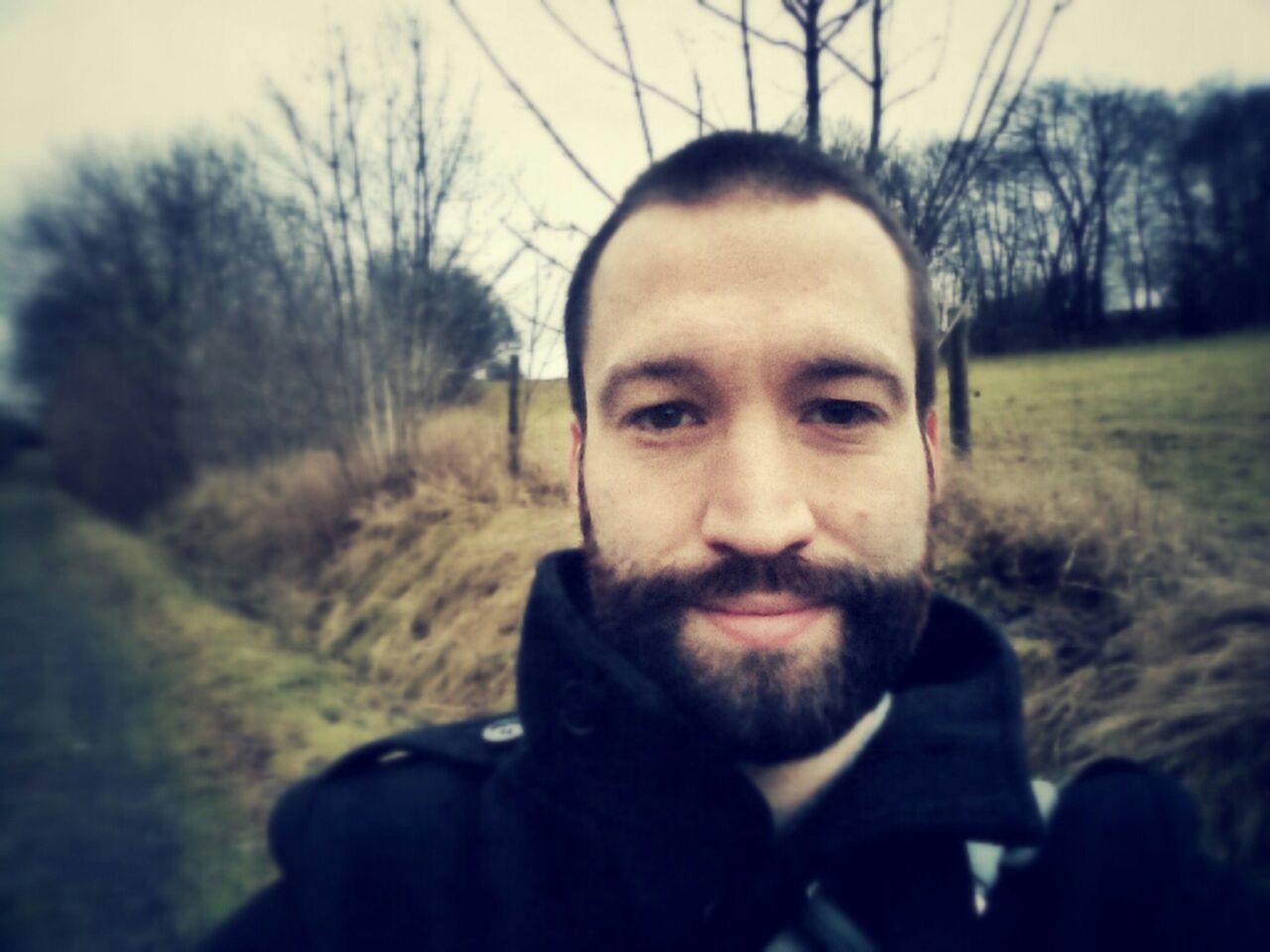 headshot, portrait, looking at camera, lifestyles, leisure activity, person, young men, young adult, focus on foreground, front view, close-up, head and shoulders, tree, human face, day, contemplation, beard