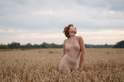 Woman standing on field against sky