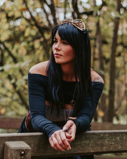 Young steampunk woman looking away while leaning on railing
