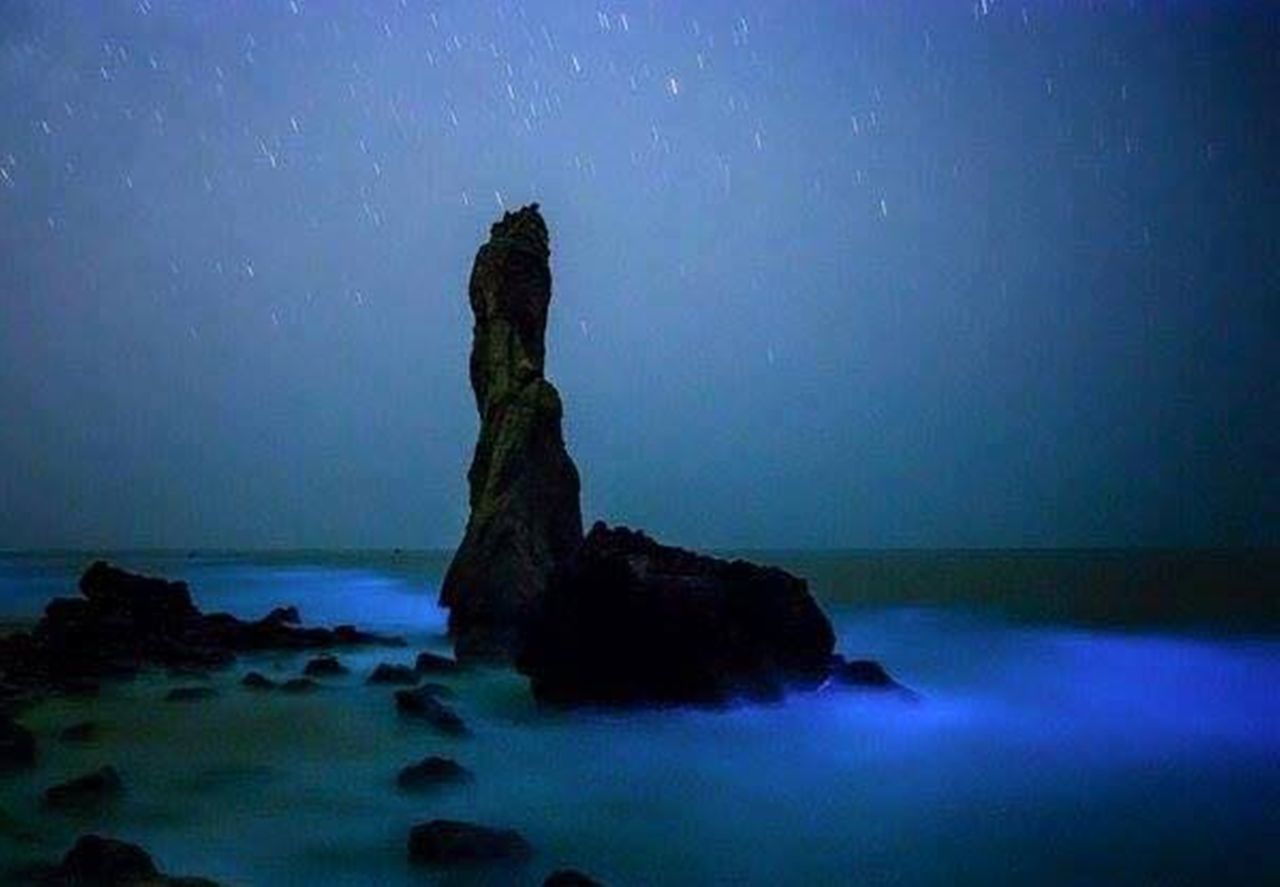 ROCKS ON SHORE AGAINST SKY AT DUSK