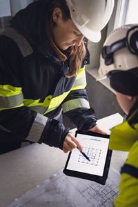 Engineers checking plans on digital tablet