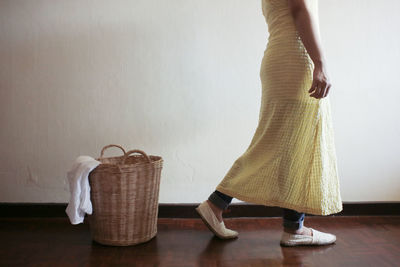 Low section of woman on floor against wall