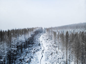 Snow covered land against clear sky