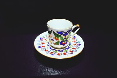 Close-up of tea cup against black background