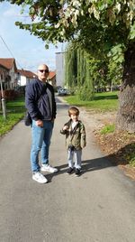 Full length of man standing with son on road