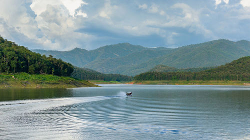 Scenic view of lake by mountains against sky