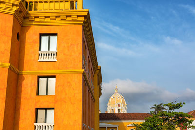 Low angle view of orange building against iglesia de san pedro claver