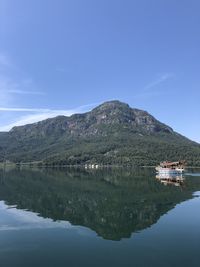 Scenic view of lake and mountains against blue sky